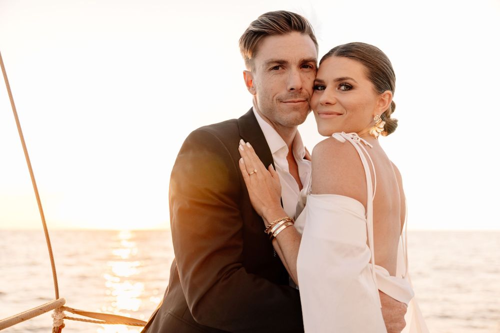 Romantic couple posing on beach during golden sunset.