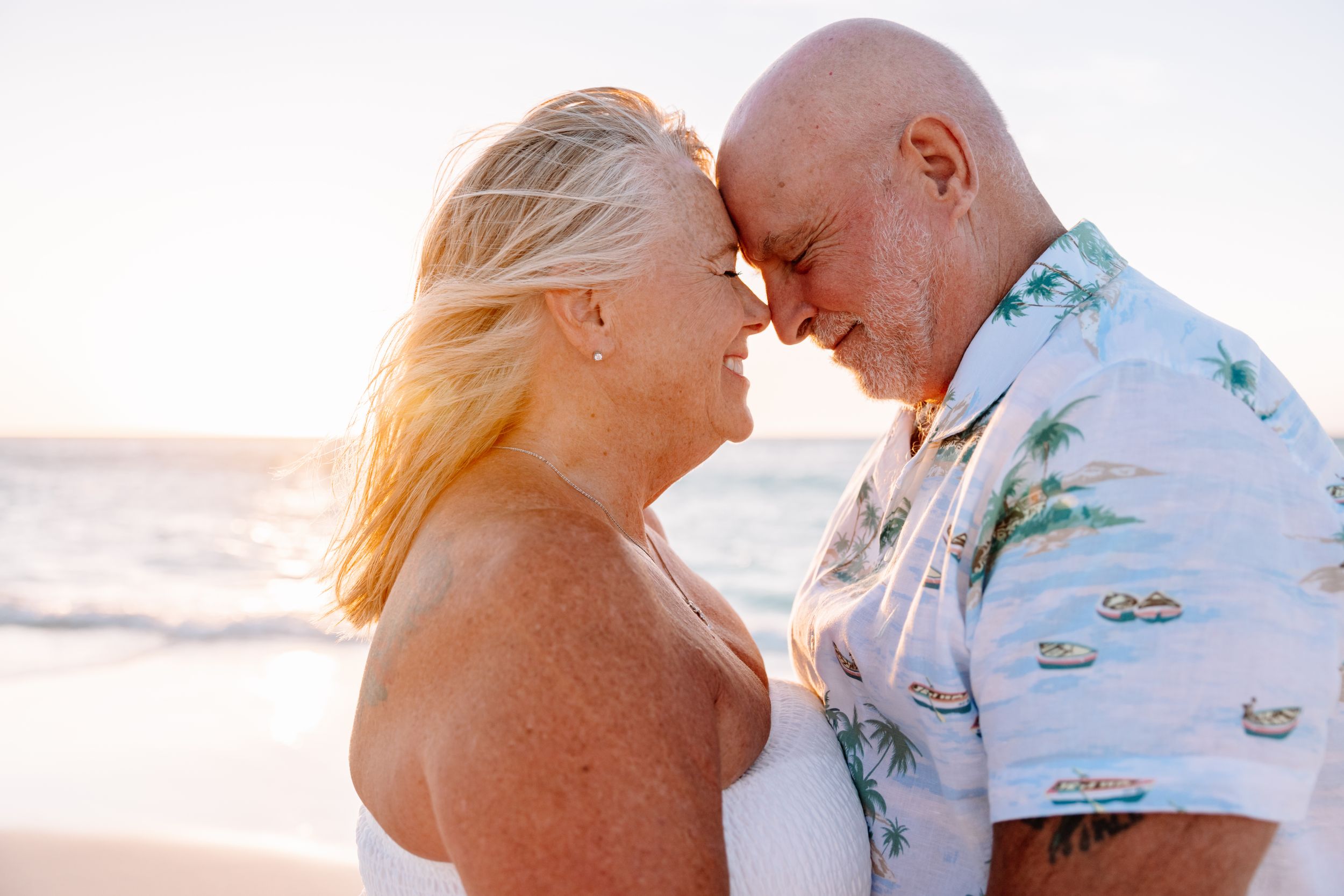 Romantic couple embracing on a bright beach during a sunny day.