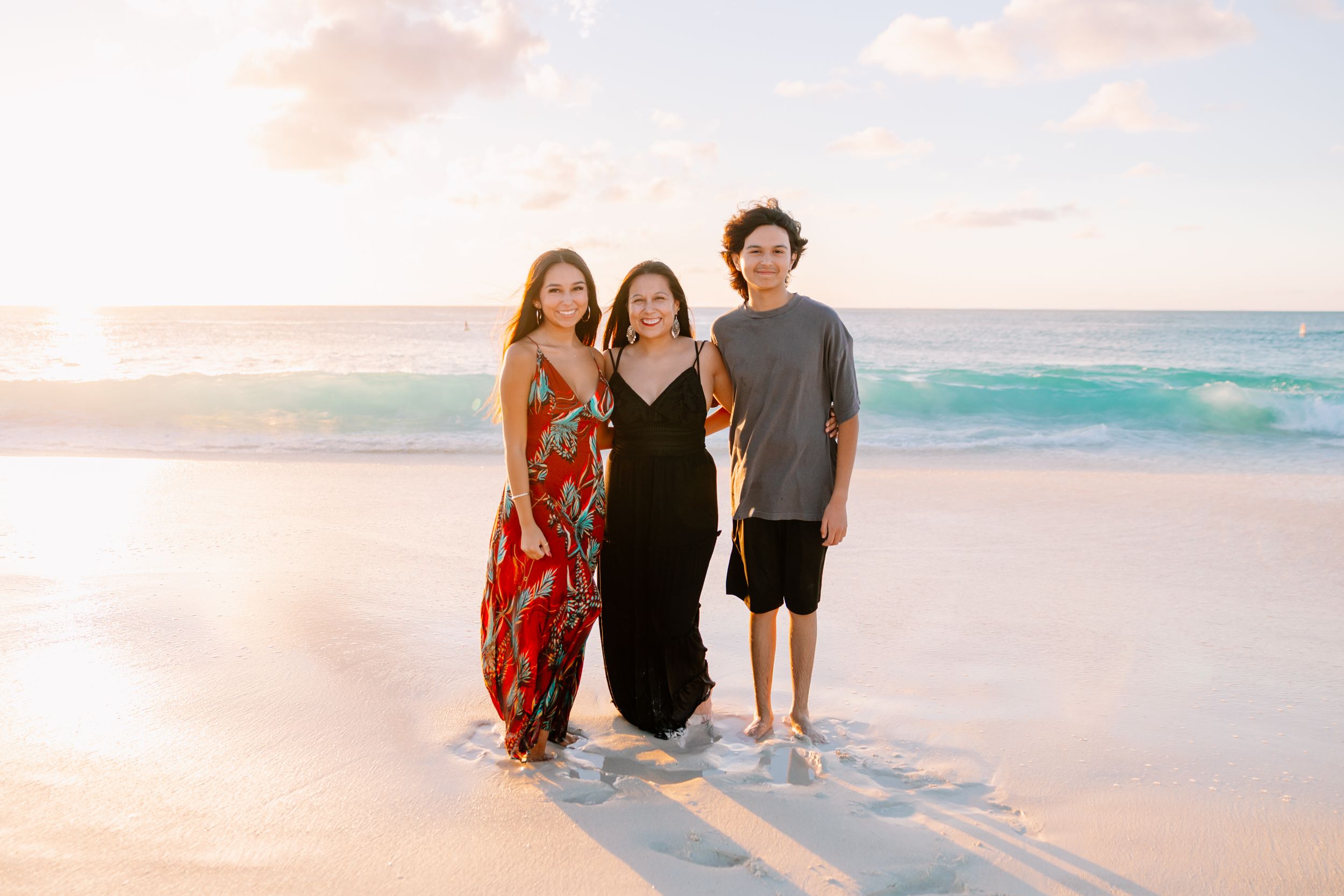 Family portrait session during sunset on a tropical white sand beach.