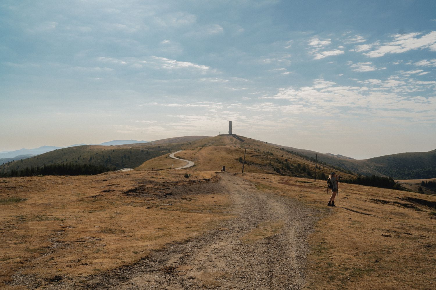 Panoramic view of rolling hills and hiking trails stretching across a mountainous landscape.