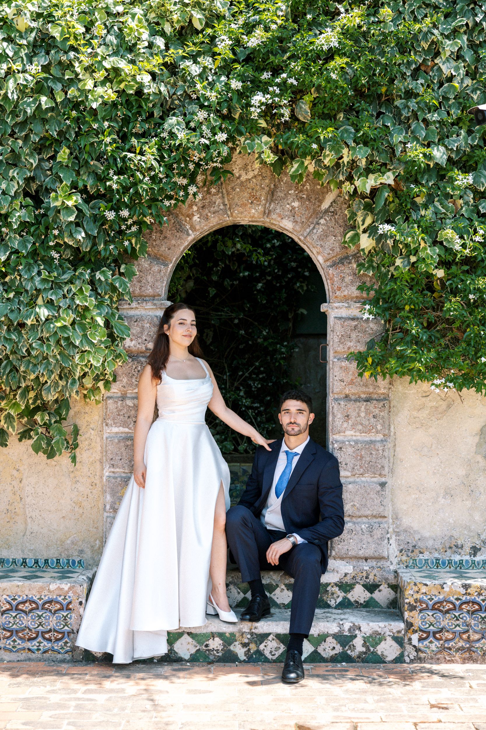 Bride and groom portrait framed by ivy arch at Portugal wedding venue