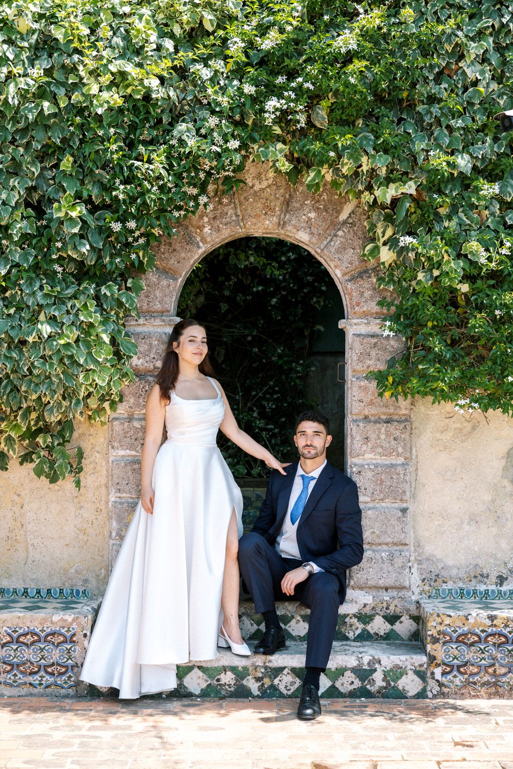 Bride and groom portrait framed by ivy arch at Portugal wedding venue