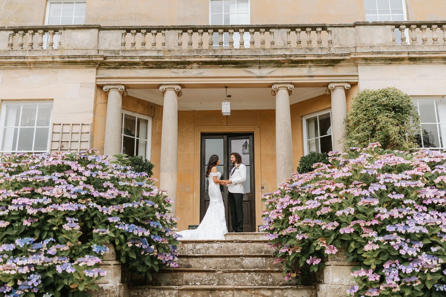 Couple shares emotional first look moment during outdoor wedding ceremony in garden setting. Hopton Court