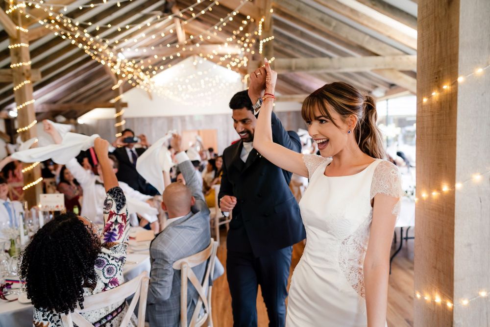 Joyful celebration with dhol drums at a multicultural fusion wedding at Bredenbury Court Barns