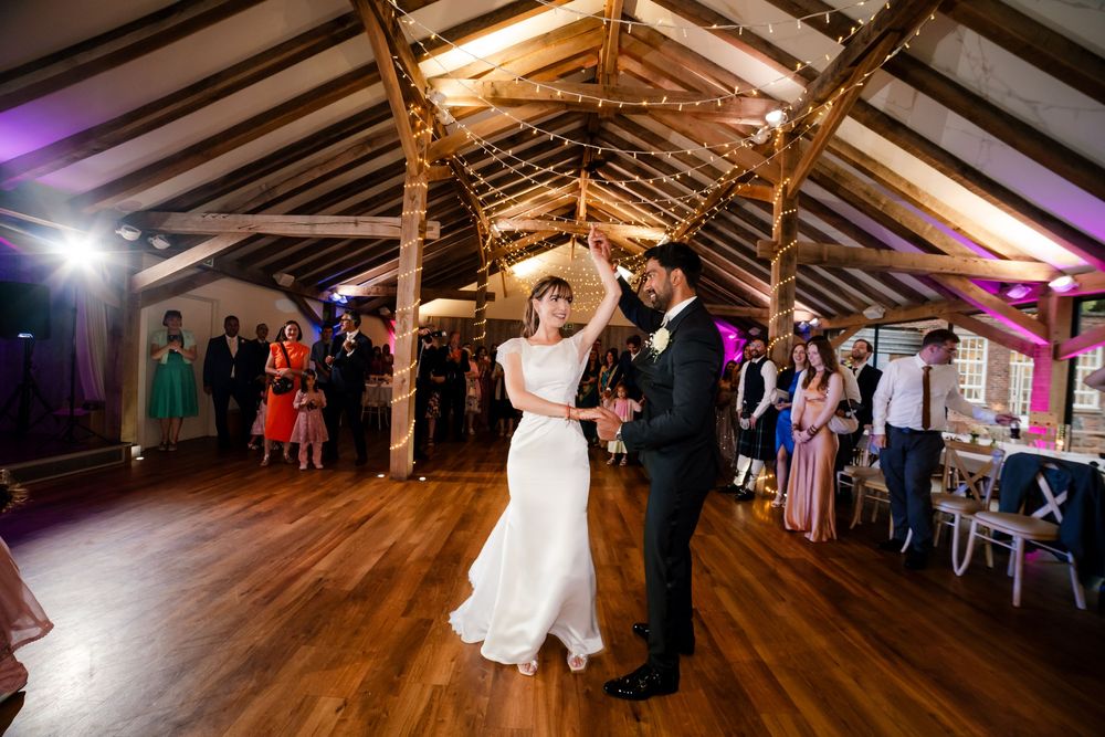 Joyful celebration with dhol drums at a multicultural fusion wedding at Bredenbury Court Barns