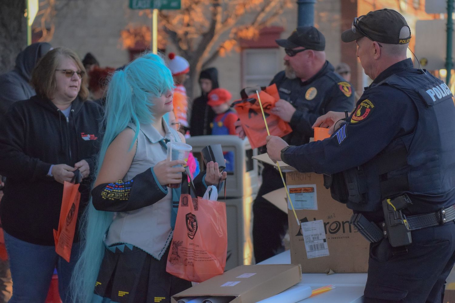 A crowd of people interact with police officers outside a building.