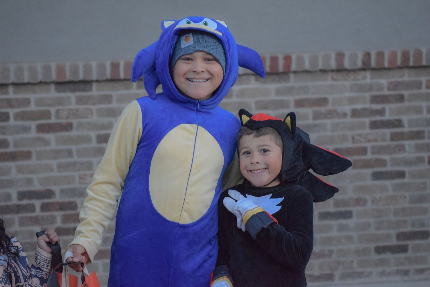 Someone wearing a bright blue costume poses with others outside a brick building.