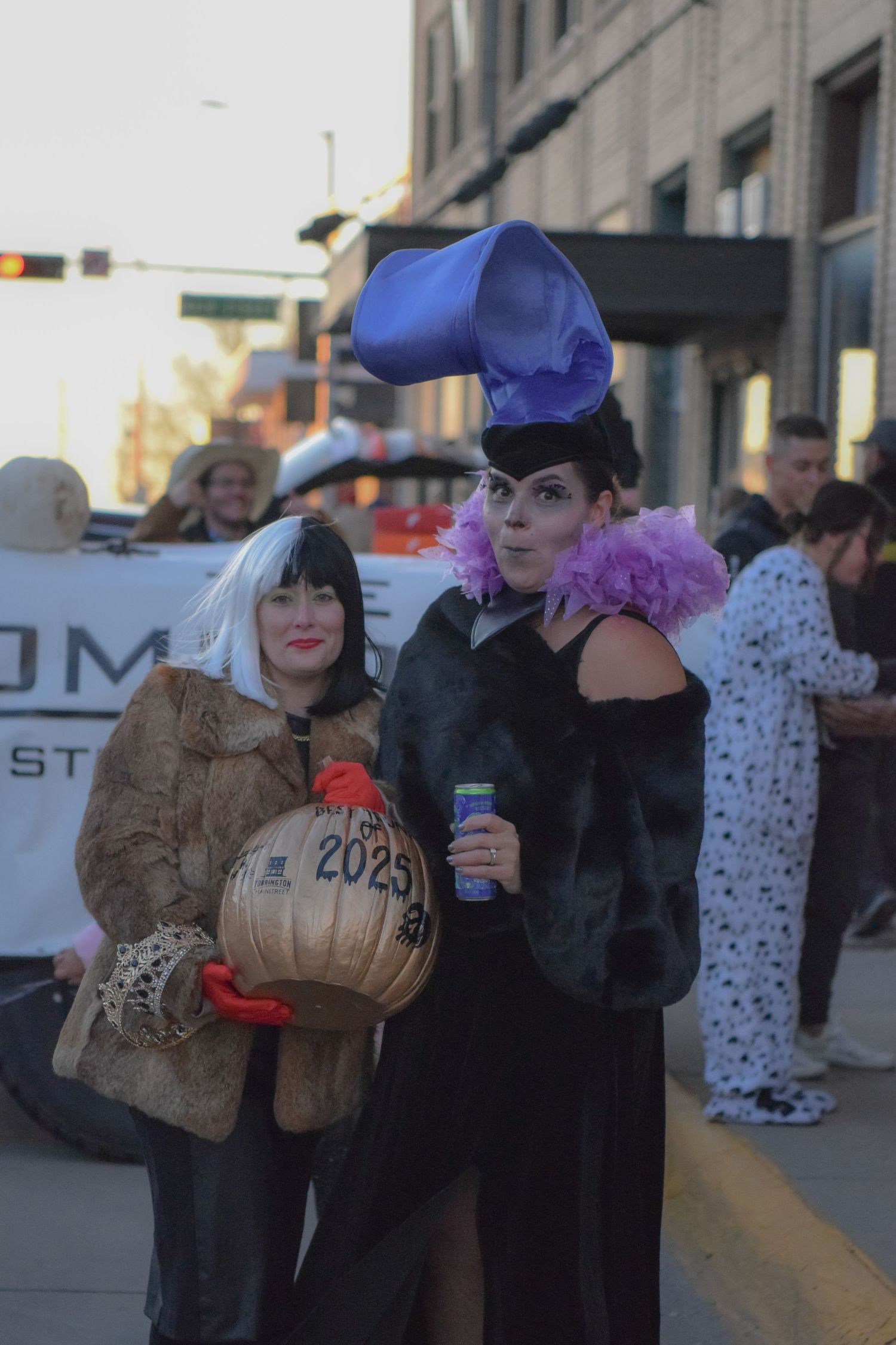 People in costumes gathering on a city street during an event.