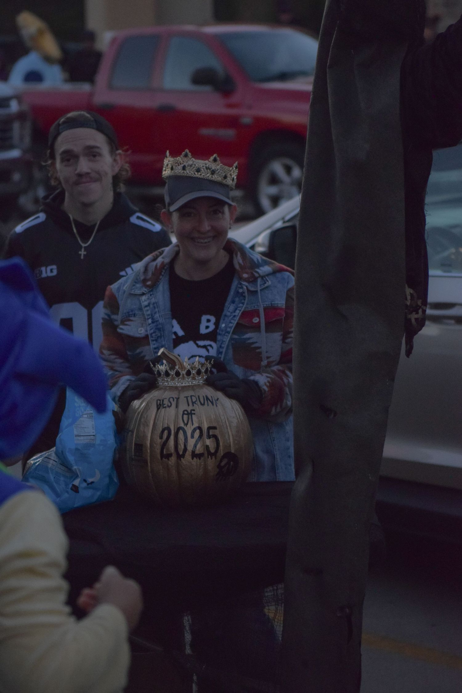 People waiting in line at dusk during an outdoor Halloween celebration.