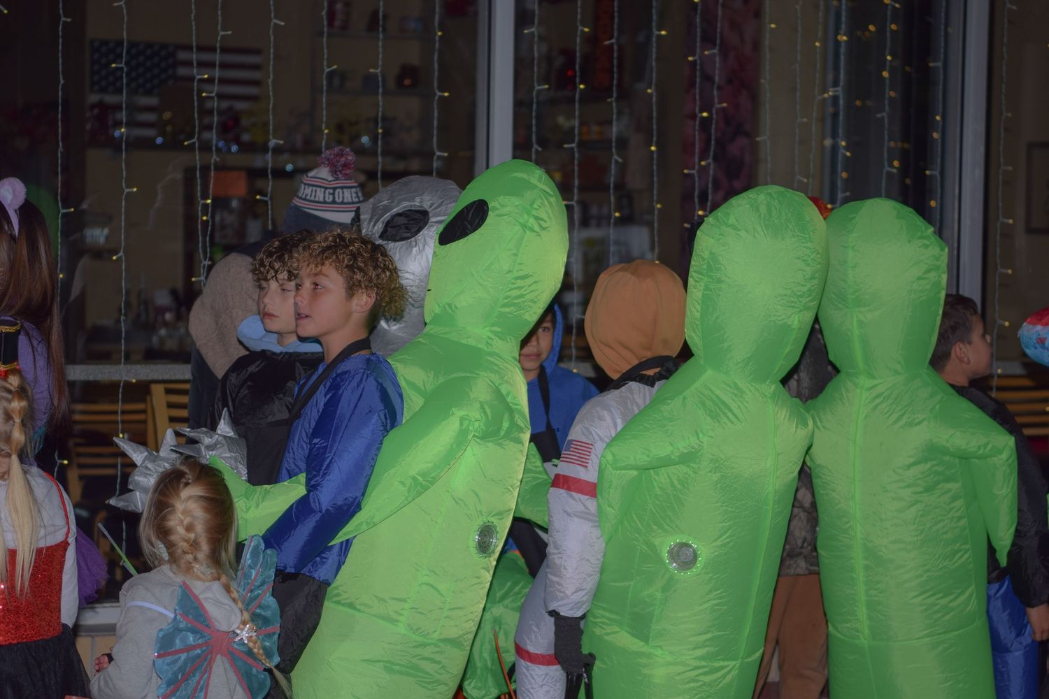 Group wearing inflatable alien costumes at a Halloween gathering.