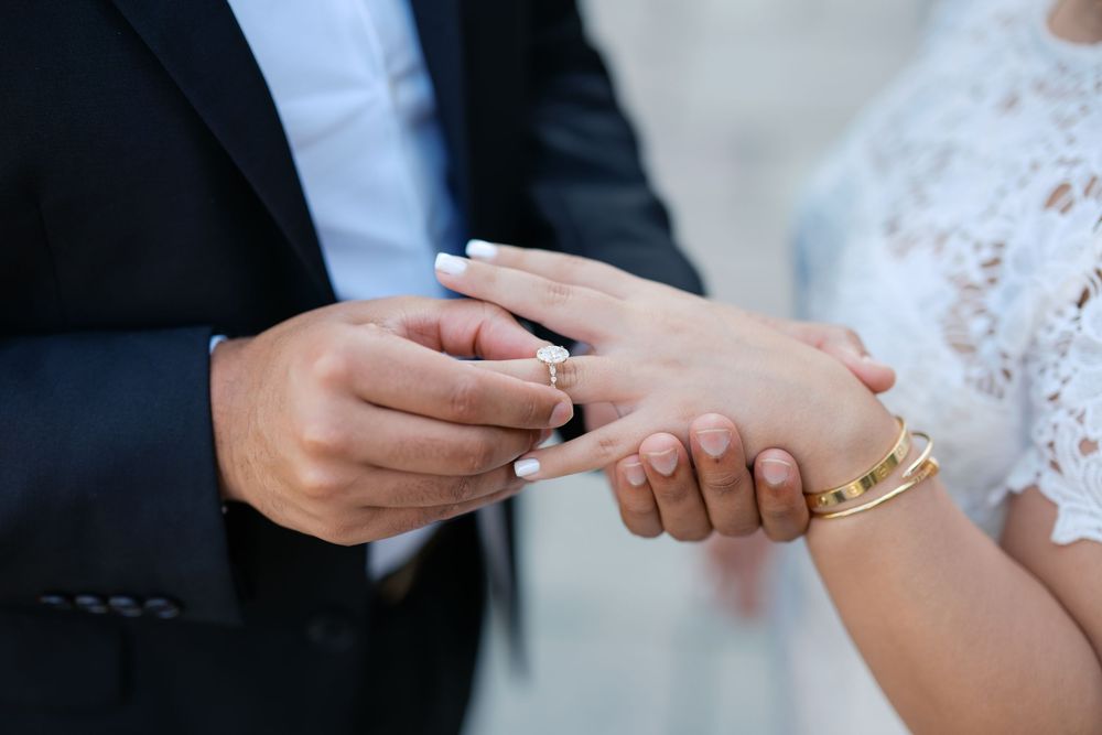 Close-up of hands exchanging wedding rings during an elegant ceremony.