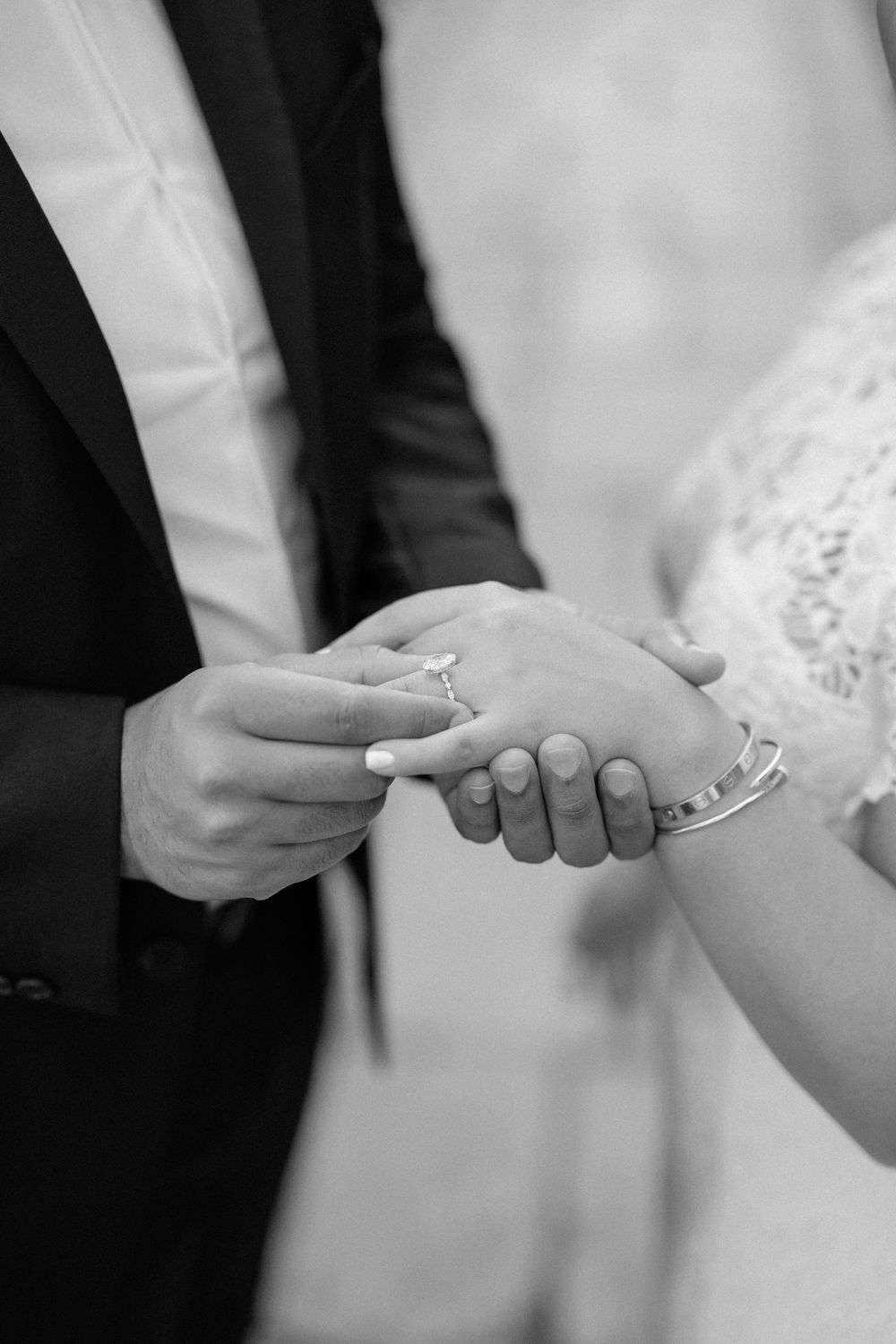 A sequence of black and white photos showing hands exchanging wedding rings during a marriage ceremony.