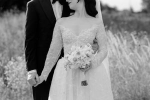 Romantic black and white wedding portraits in a field with soft natural lighting.