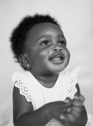 Black and white portrait series captures child's delightful expressions and laughter.