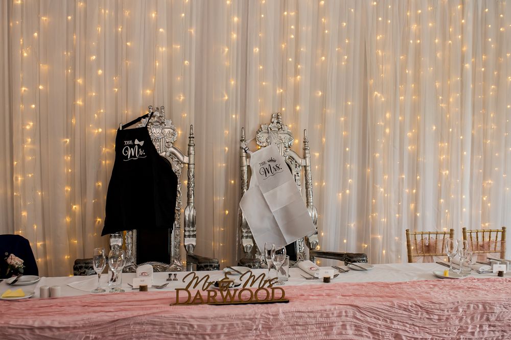 Elegant reception hall with twinkling fairy light backdrop and formal table settings.
