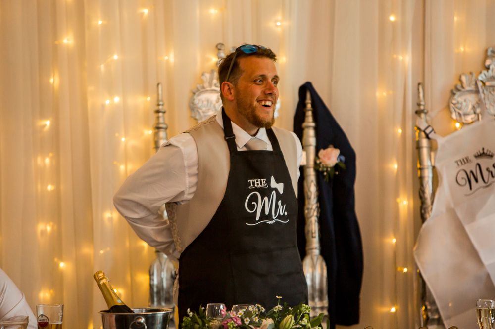 Wedding reception venue with twinkling fairy lights and elegant white backdrop.