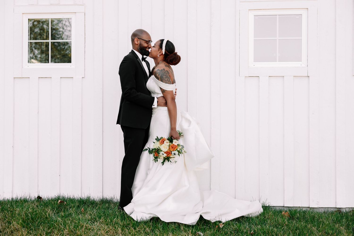 Classic white barn wedding venue with romantic couple portraits.