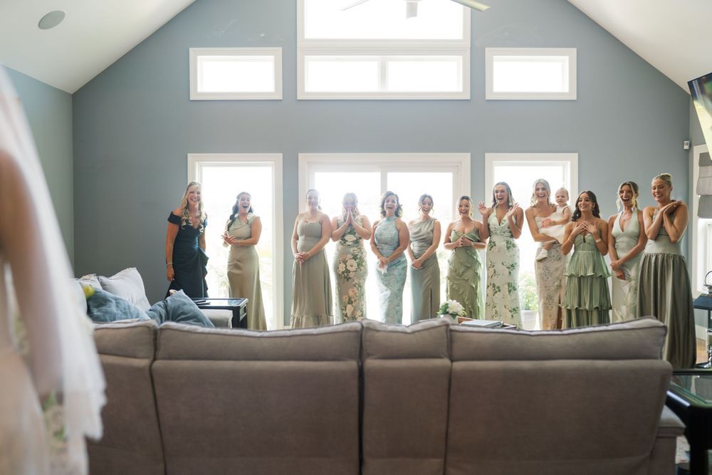 Wedding party gathered in bright room with large windows and modern decor.
