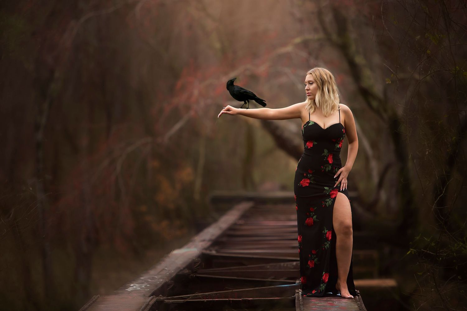 Moody portrait session on wooden walkway with dramatic red and dark tones.