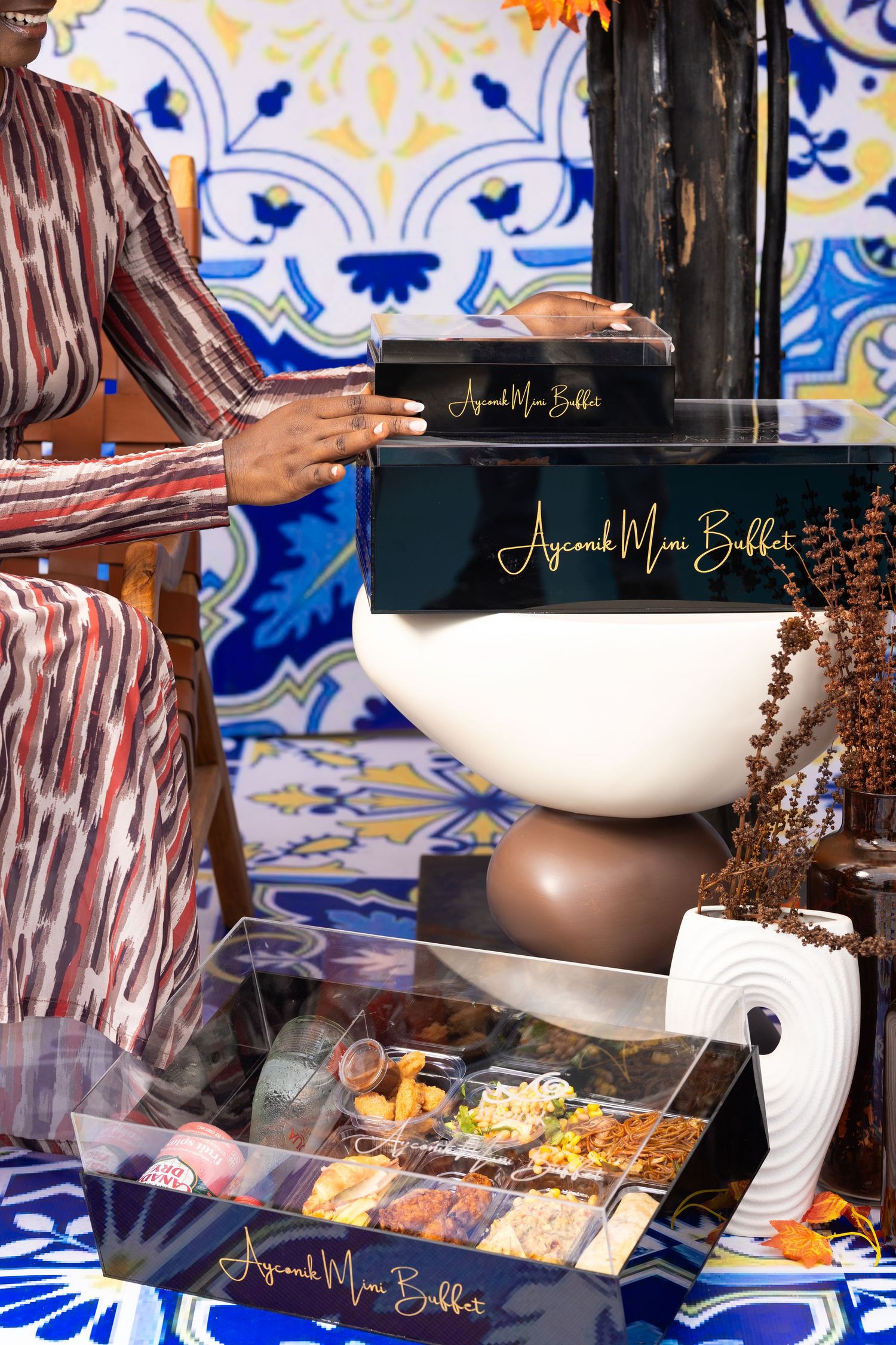 Colorful display of food items against blue and white patterned tiles with decorative serving bowls.
