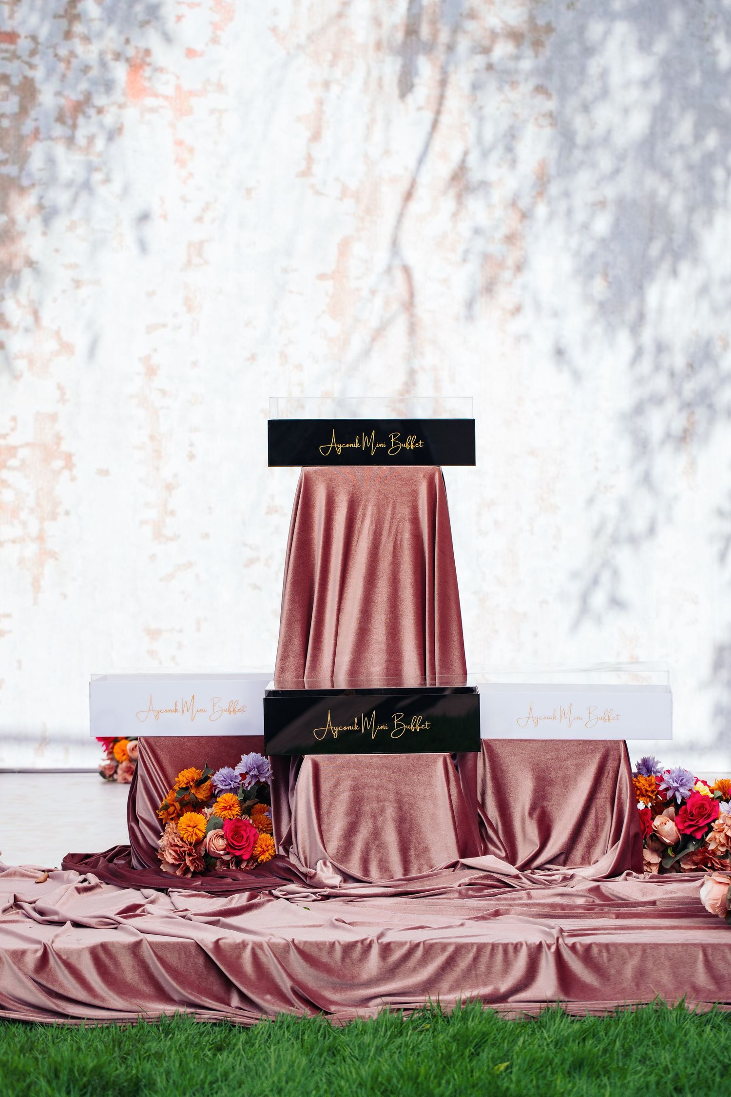 Professional event display with rose gold satin tablecloth and black branded name plates.