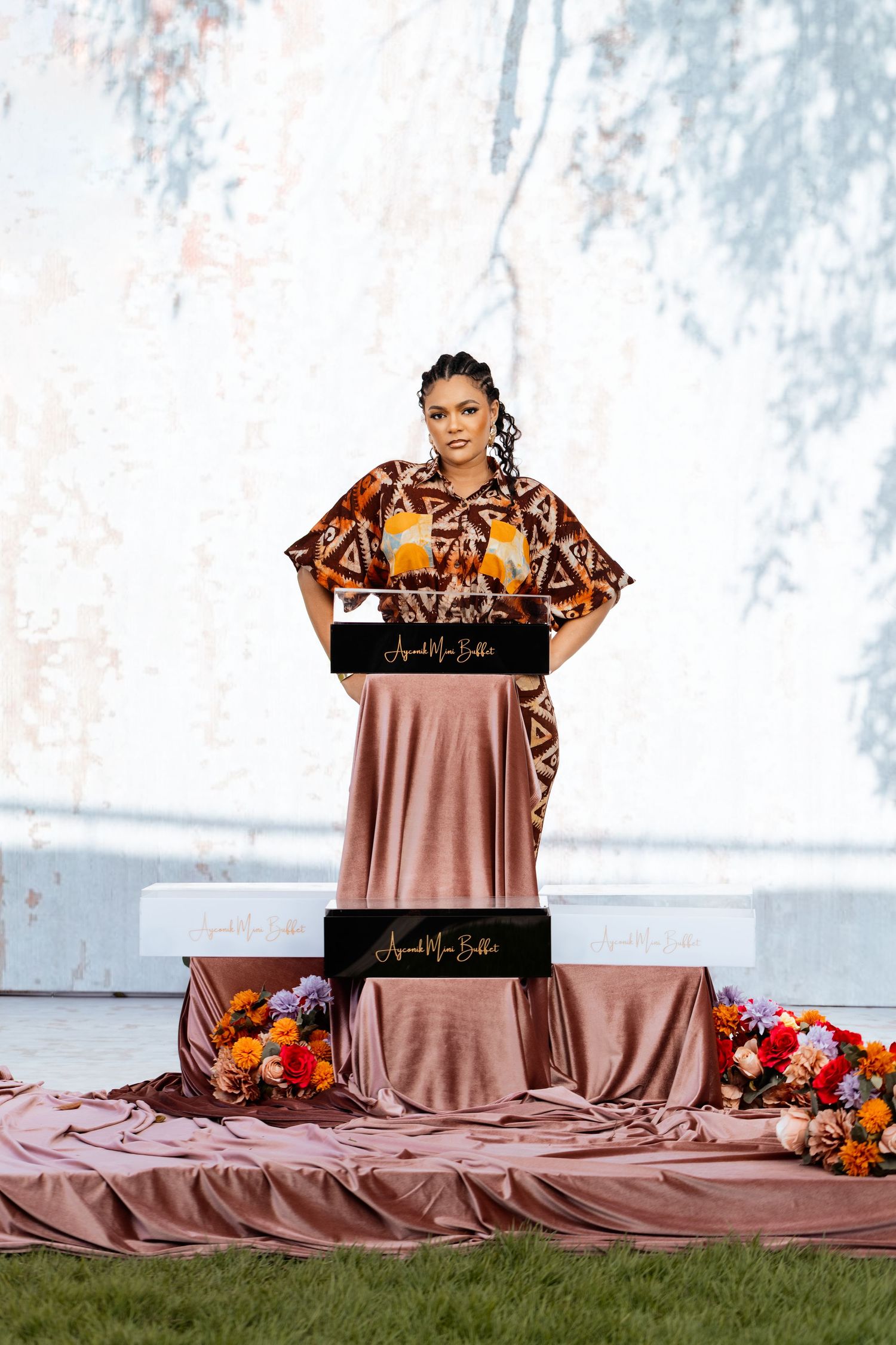 Elegant display setup with brown satin tablecloth and black branded signage.