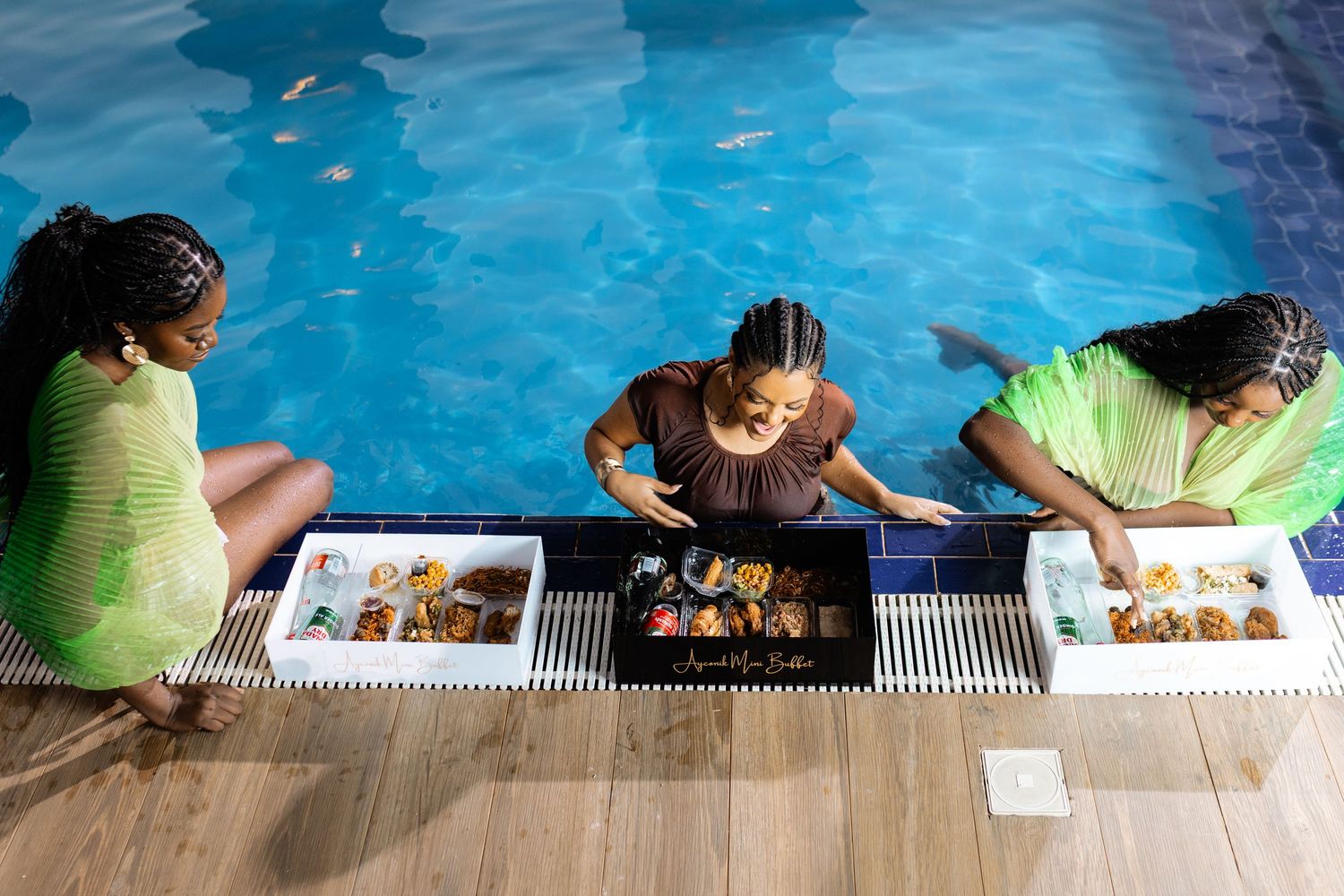 People relaxing at edge of blue swimming pool on sunny day.