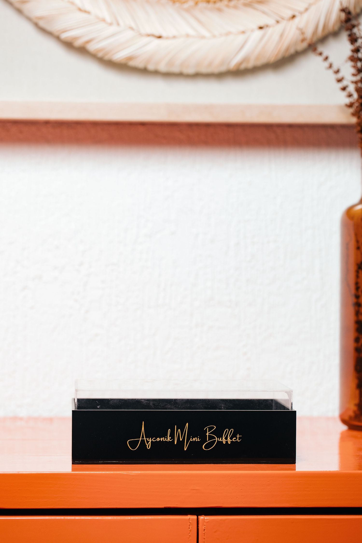 Black decorative box with gold lettering displayed on an orange surface.