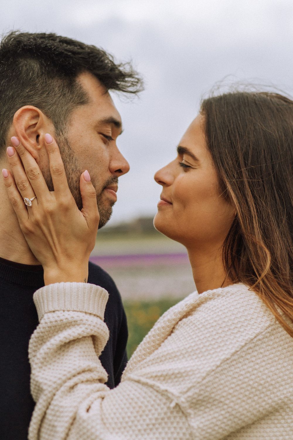 Romantic couple sharing an intimate moment in cozy sweaters outdoors.