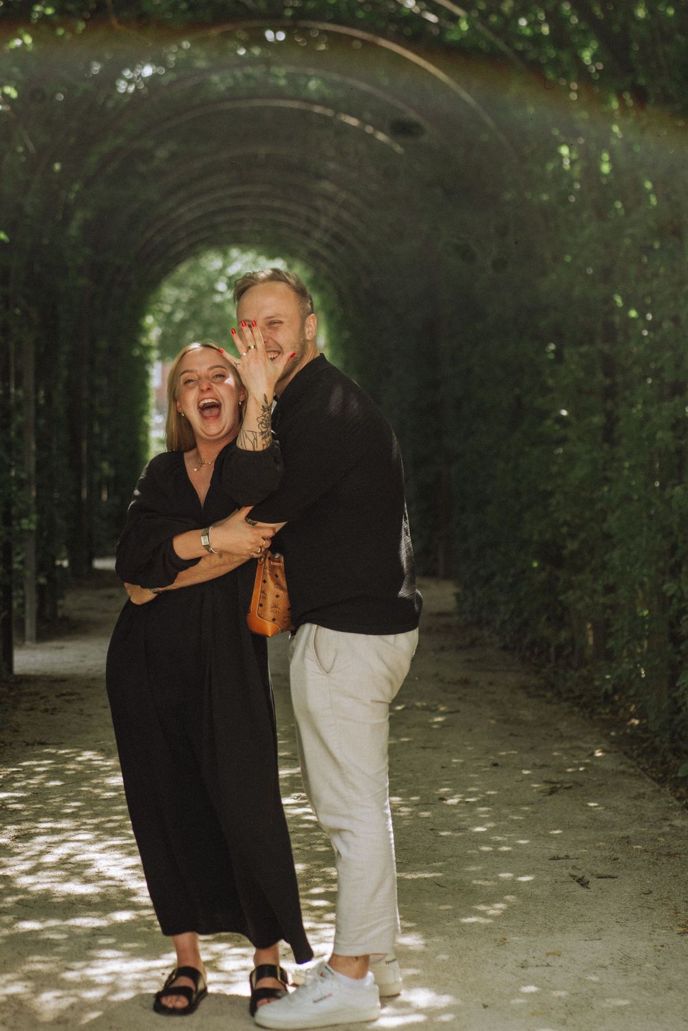 Joyful moment shared under a green garden tunnel.