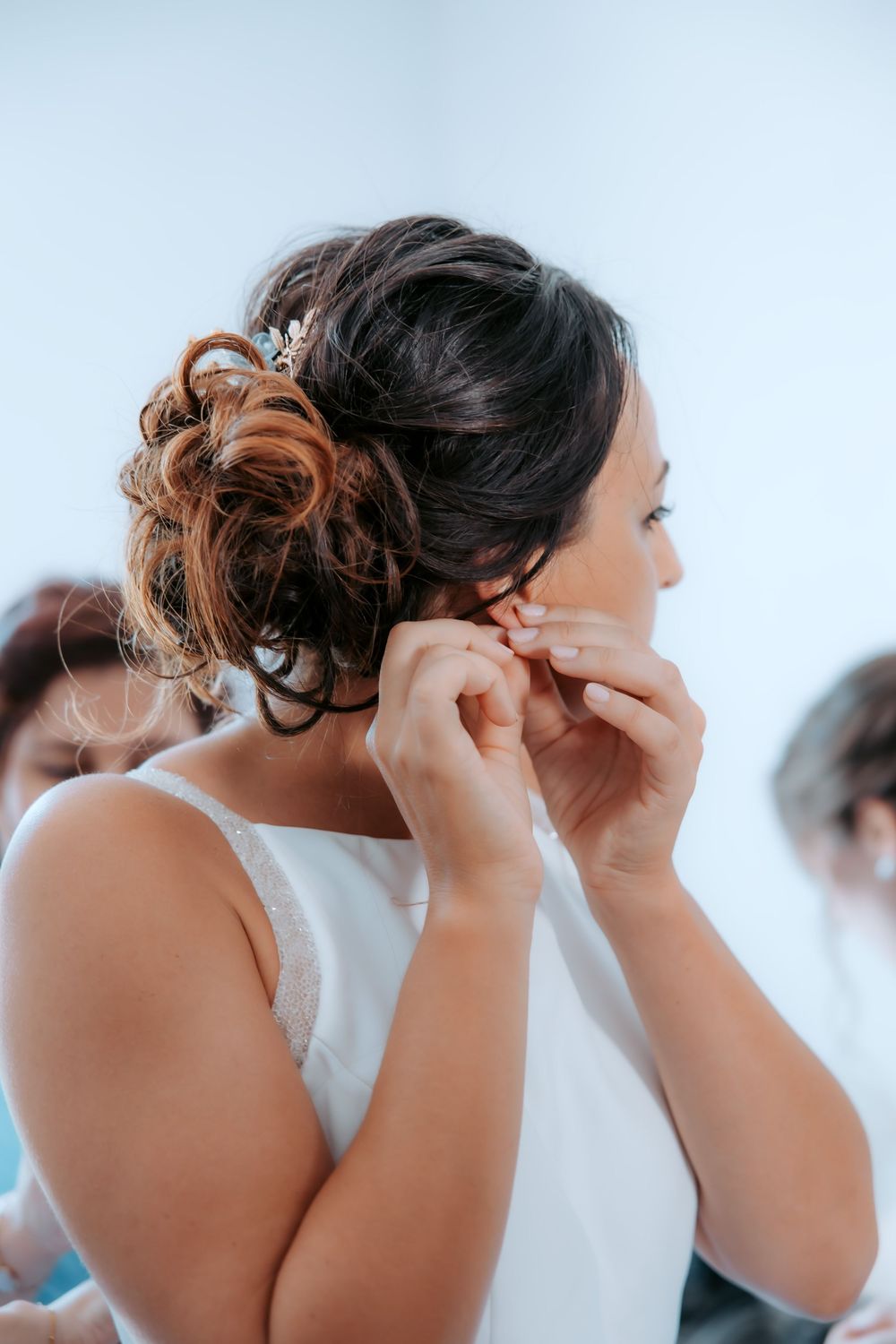 Final touches being added to bridal hairstyle with elegant curls.