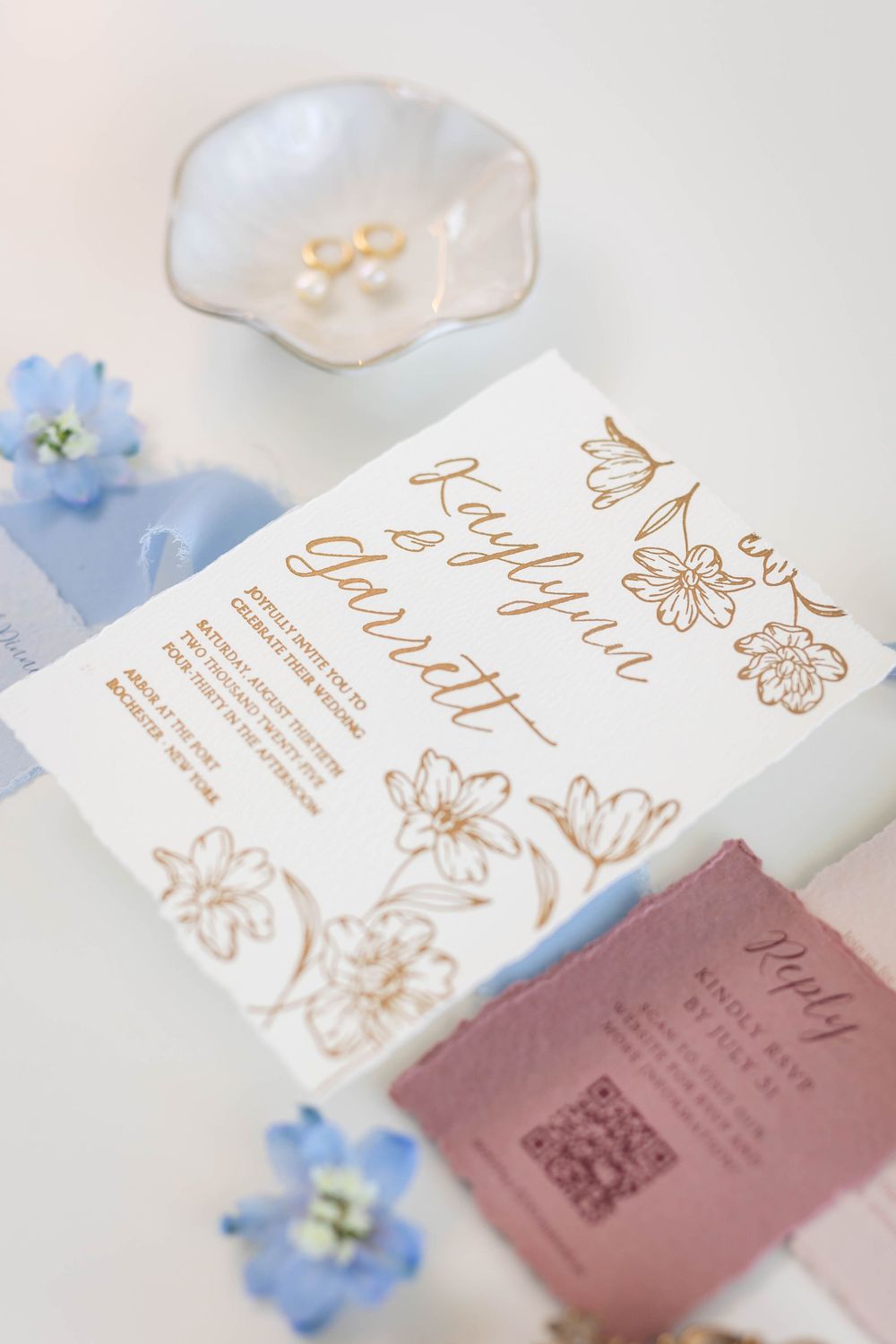 Elegant wedding invitation cards with gold floral designs and blue accents.