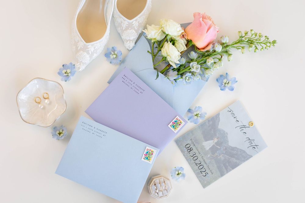 Delicate wedding stationery in soft pastel colors with floral accents and envelopes.