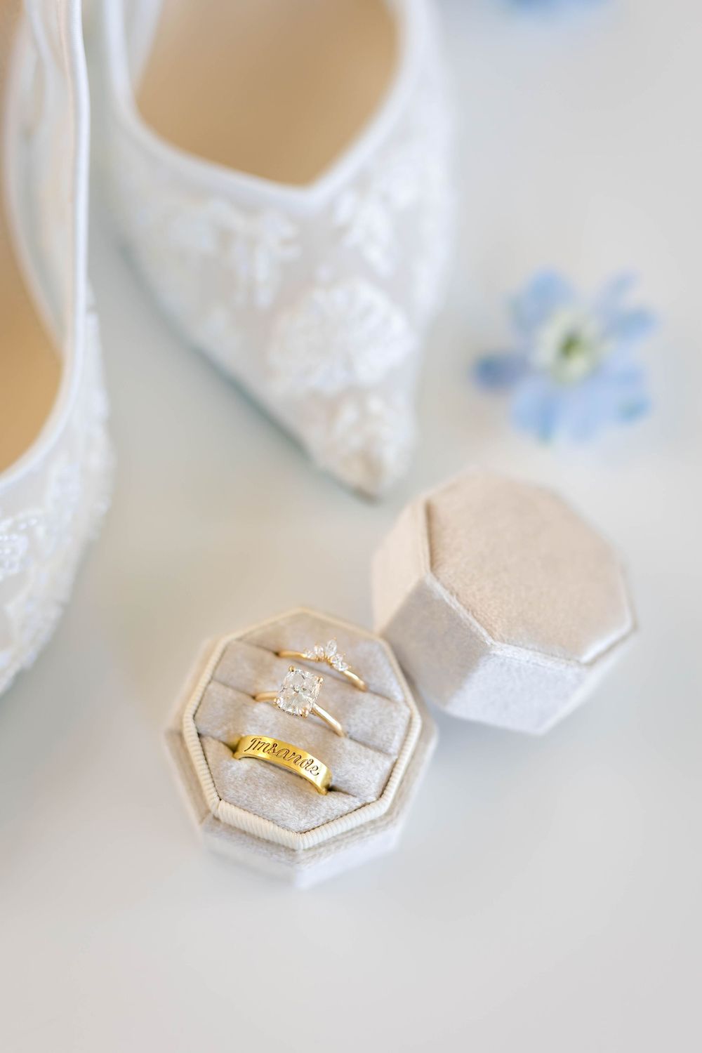 Close-up of elegant wedding rings displayed on light-colored hexagonal ring holders.