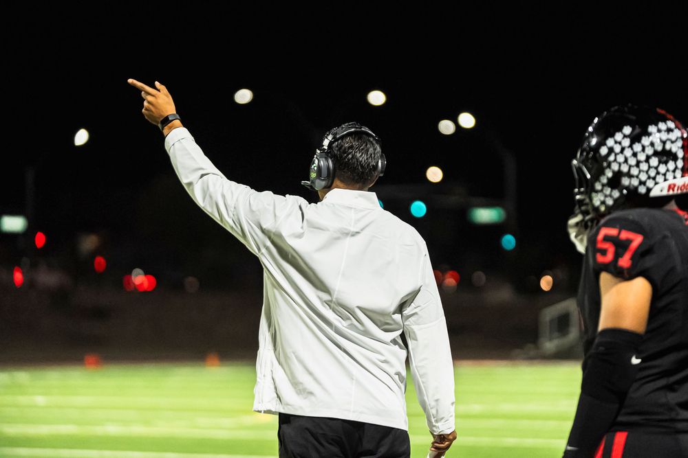 Football coach pointing off left