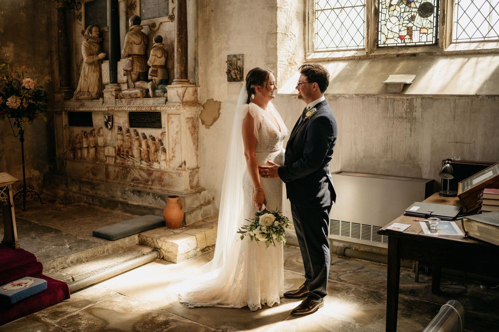 Bride and groom at the altar of a historic church flooded with natural light, Surrey wedding