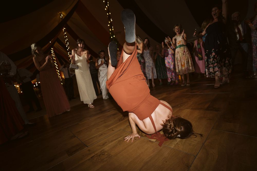 Wedding guest performing an acrobatic move on the dance floor at a Surrey wedding reception