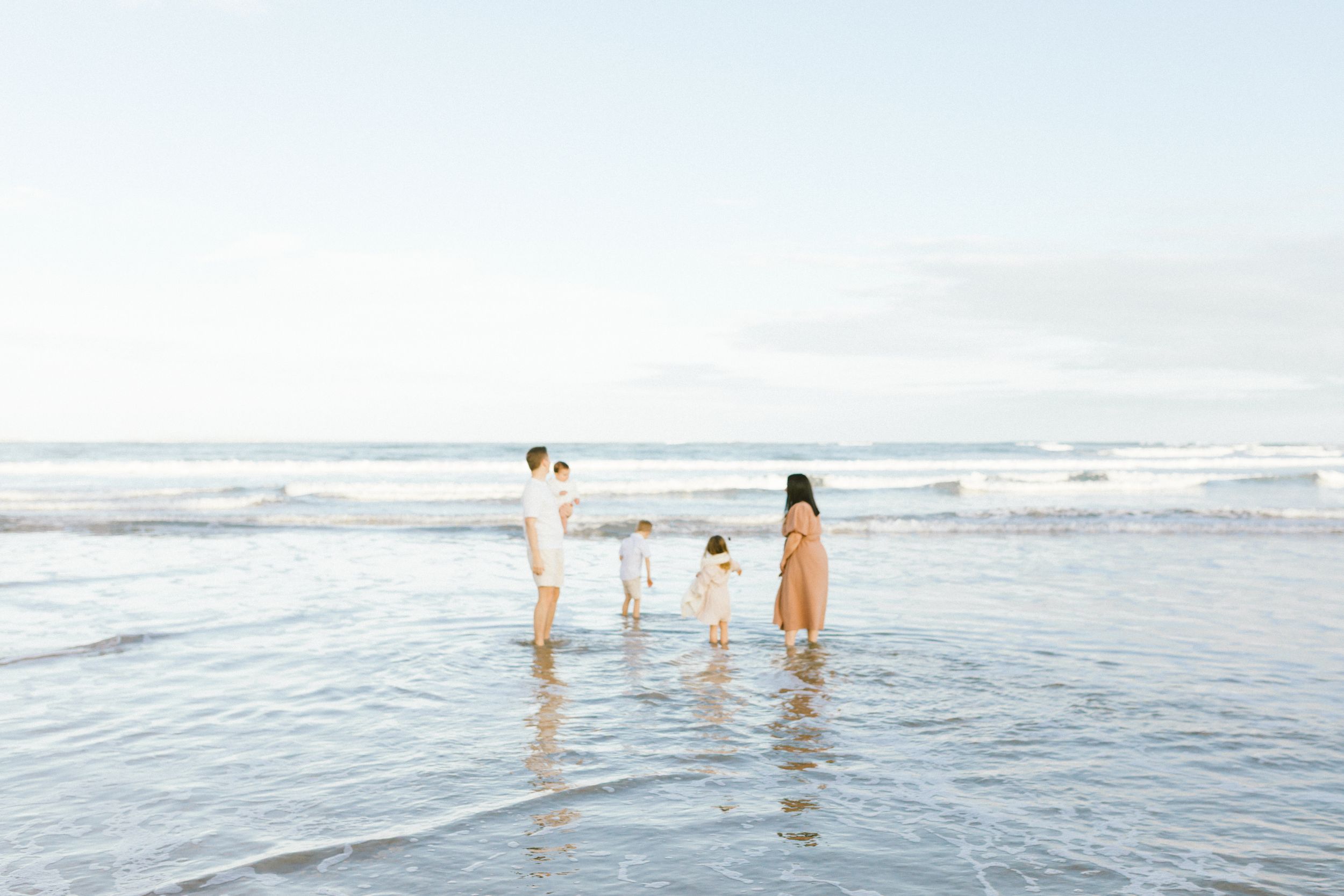 People enjoying the ocean waves at a scenic beach on a bright sunny day.