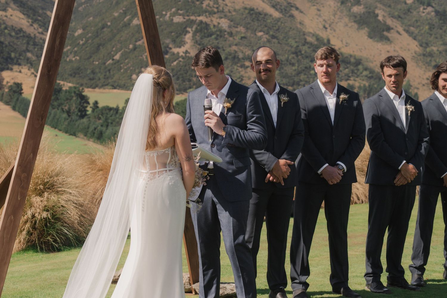 Wedding party stands together on a scenic mountain overlook during an outdoor ceremony.
