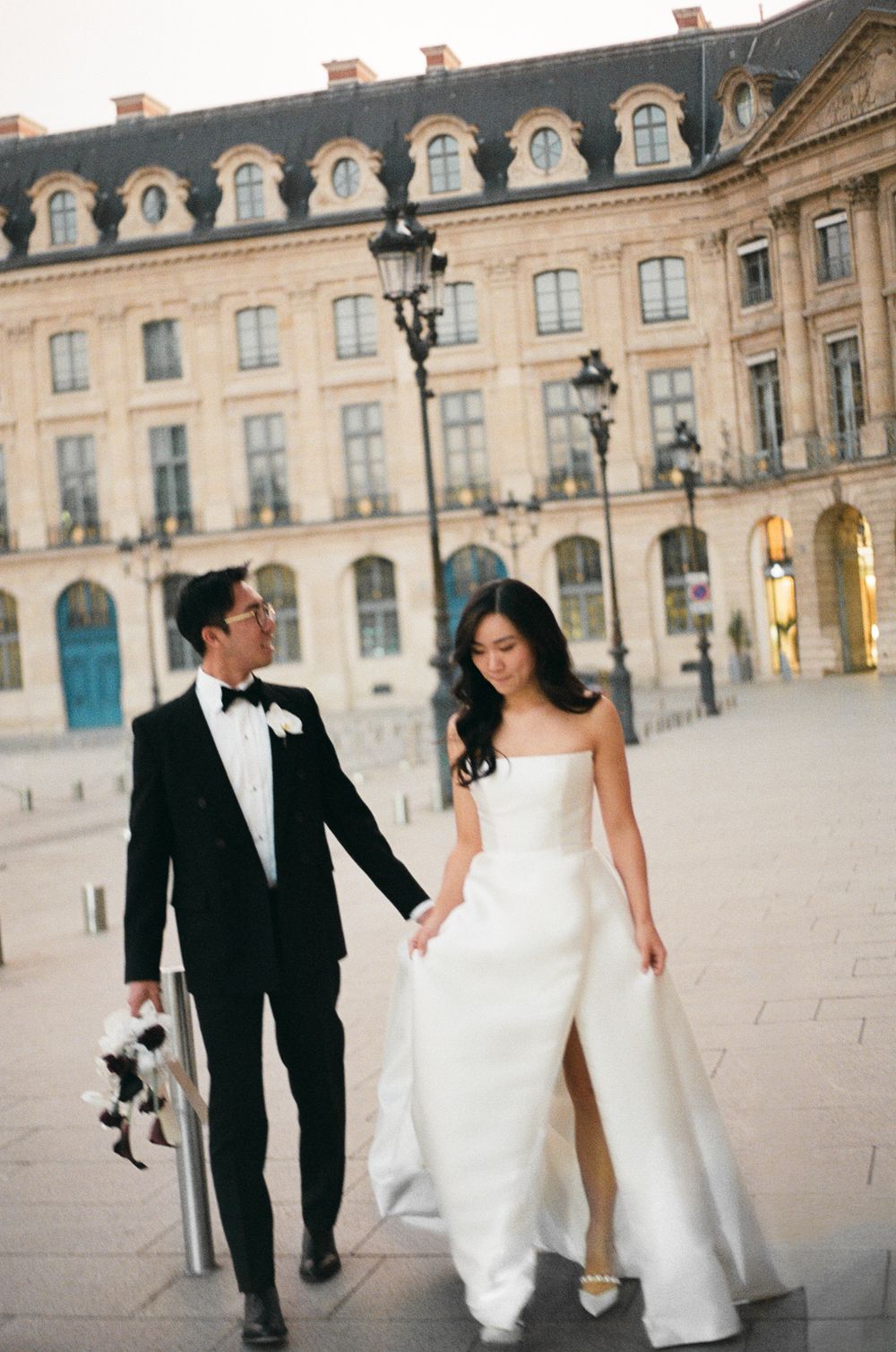 Elegant bride and groom walking hand in hand at Place Vendôme Paris, paris film photography, paris film wedding photos, paris film photograh