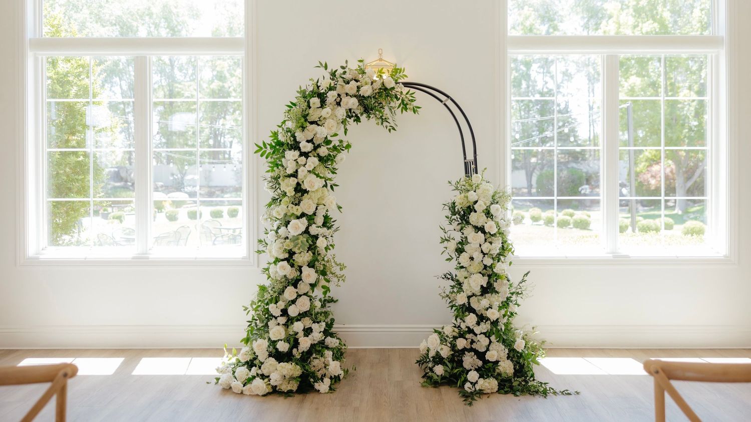 Bridesmaids holding rustic woven baskets filled with elegant white and green floral arrangements at a wedding ceremony.