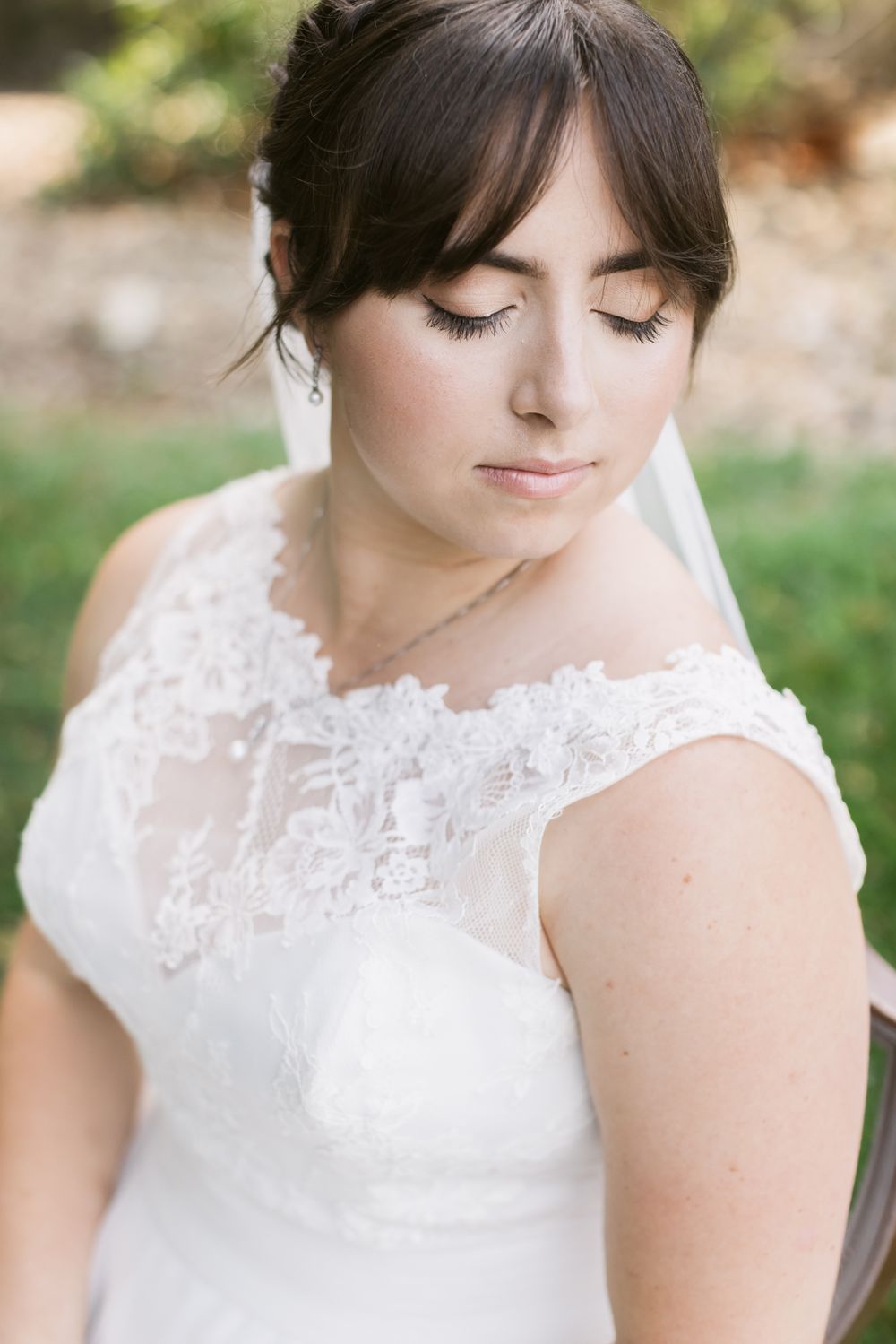 Close up of brown haired bride looking down for bridal portraits. Lakes Region Alton Bay, Wolfeboro wedding photographer