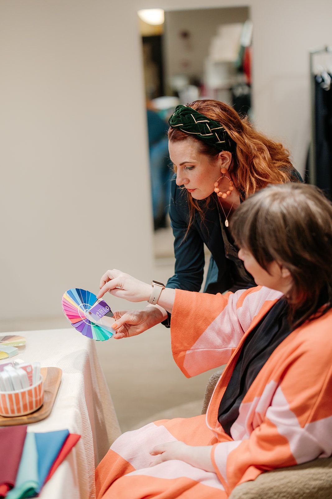 Two people looking at color swatches while sitting together in an office setting.