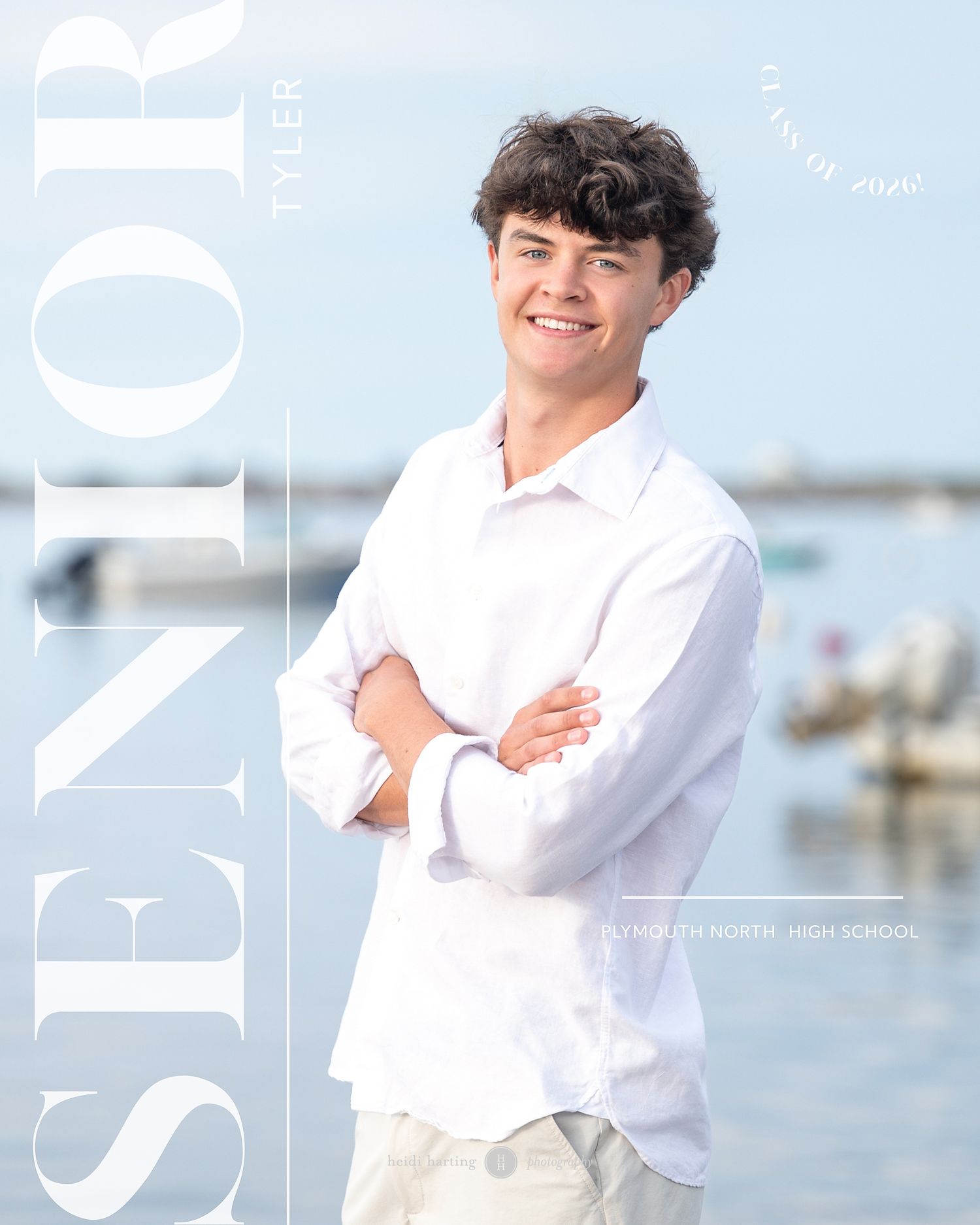 Person in white shirt smiling against blurred coastal background during outdoor photo session.