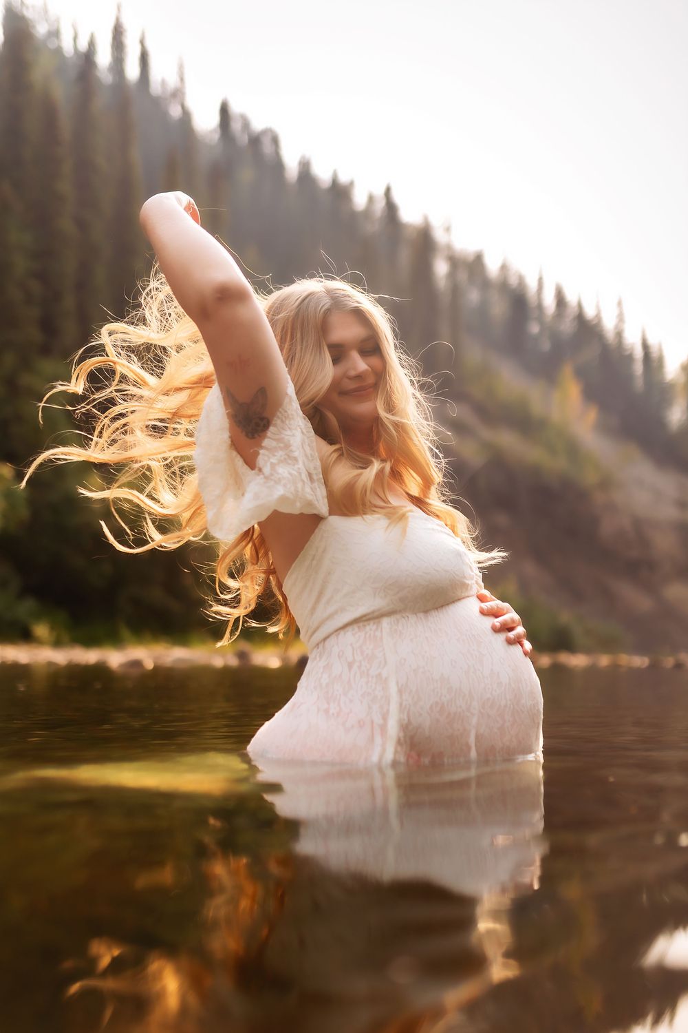 A figure in a flowing white dress twirls gracefully by a serene lake at sunset, creating a dreamy silhouette.