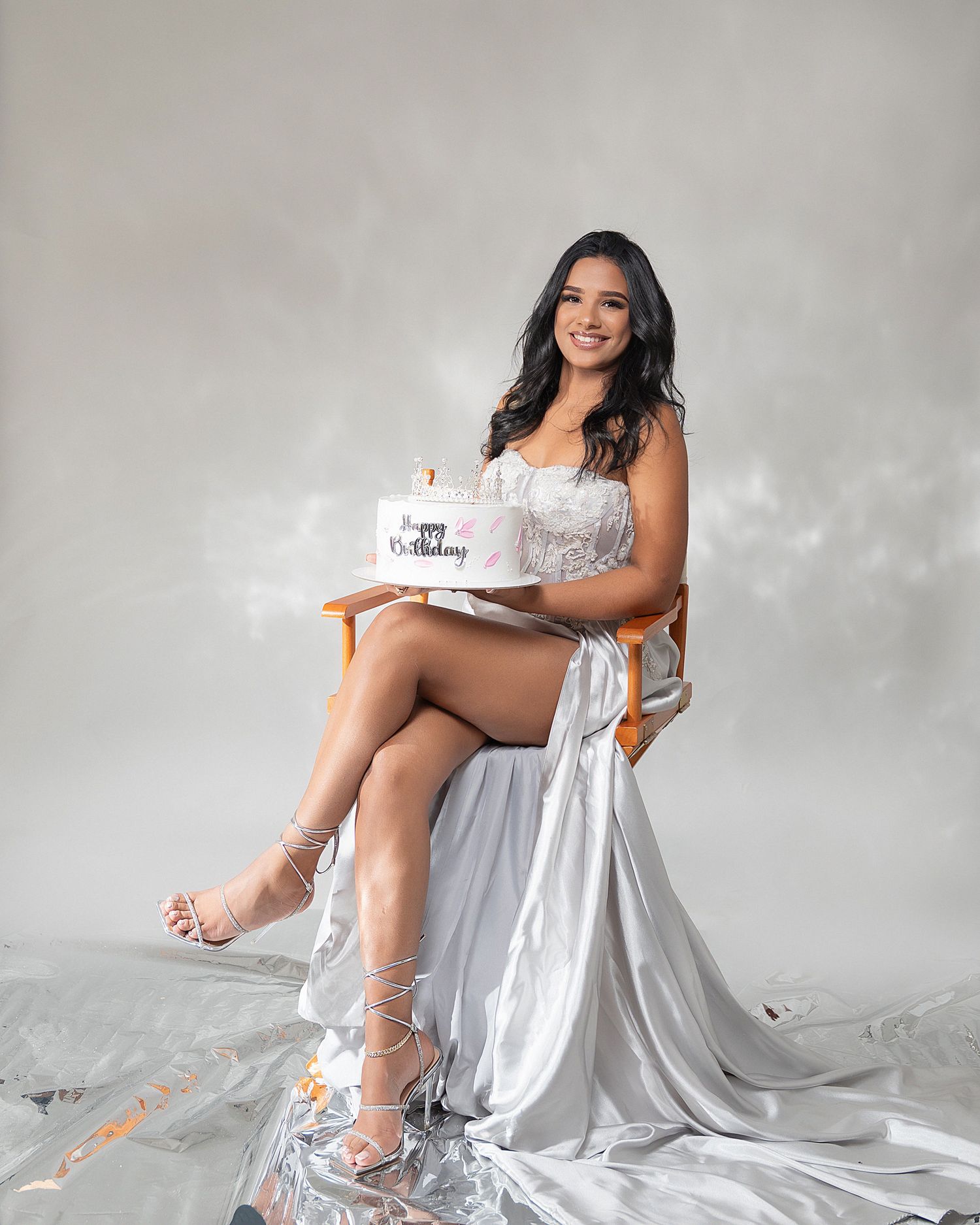 A series of maternity photos showing a woman in a black dress against a gray background posing with her baby bump.