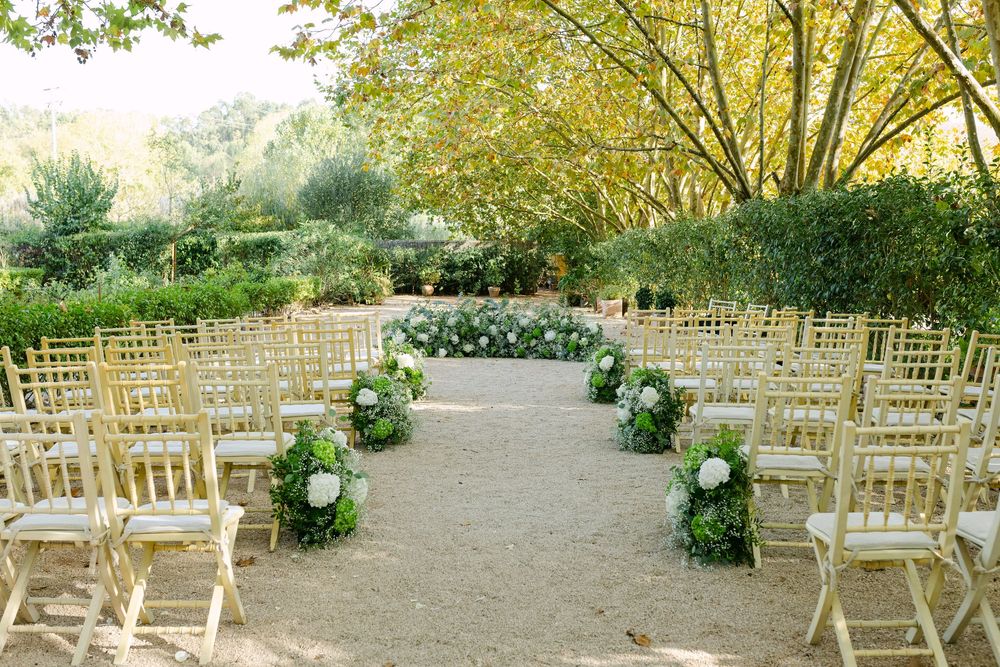 Rustic wedding seating chart with flowers and glass bottles against yellow wall at Quinta Nova do Hespanhol Lisbon