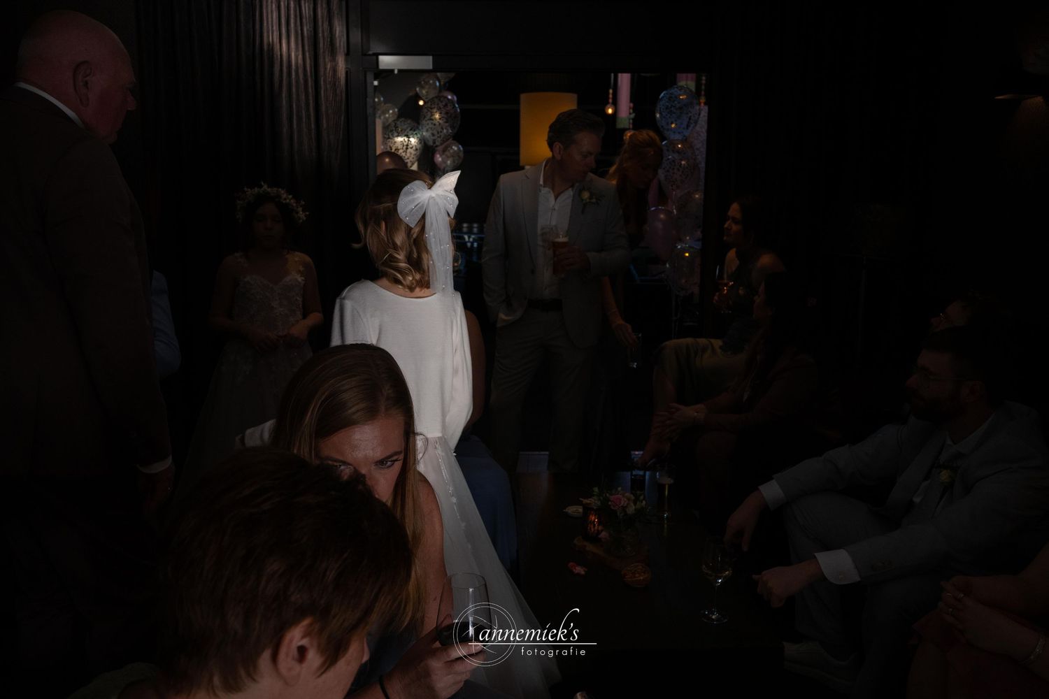Dimly lit nightclub scene with people dancing and socializing in a crowded space.