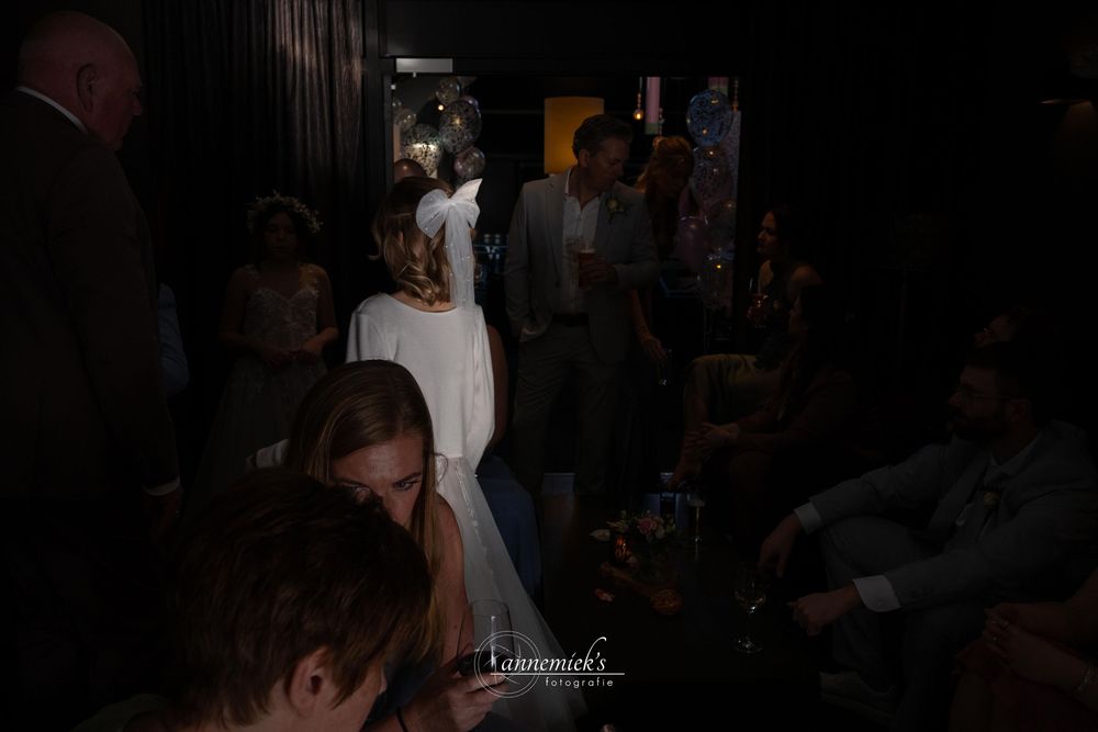 Dimly lit nightclub scene with people dancing and socializing in a crowded space.