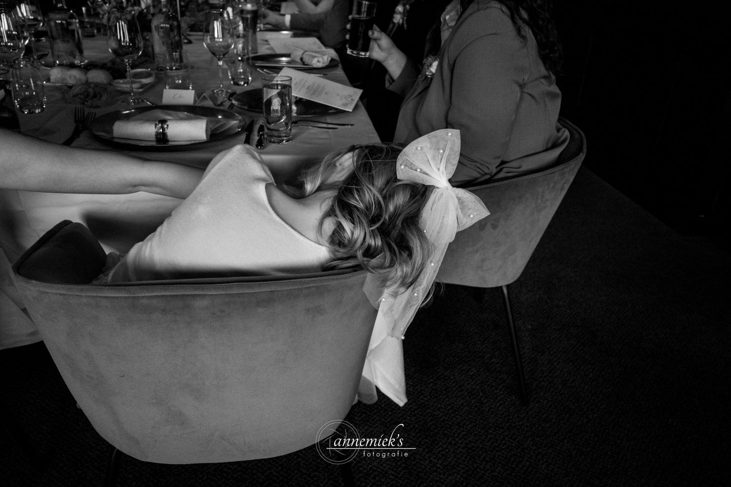 A black and white photograph shows someone reclining in a salon chair during a hair washing service at a beauty salon.